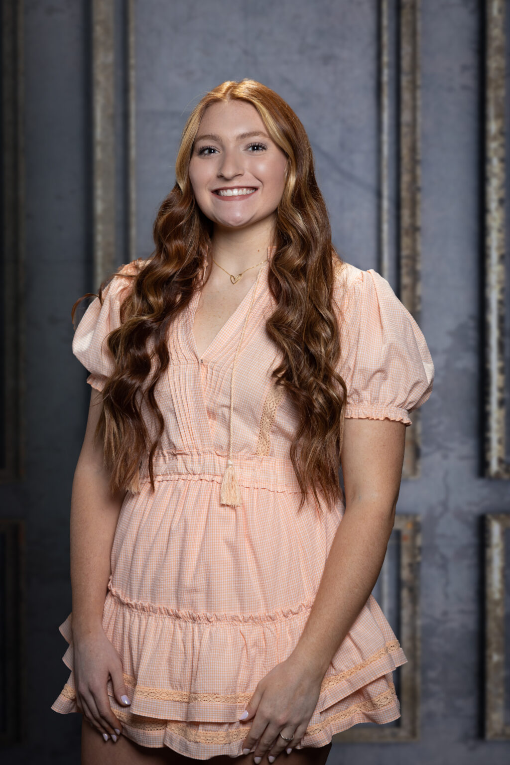 A girl wearing pink dress, smiling at the camera