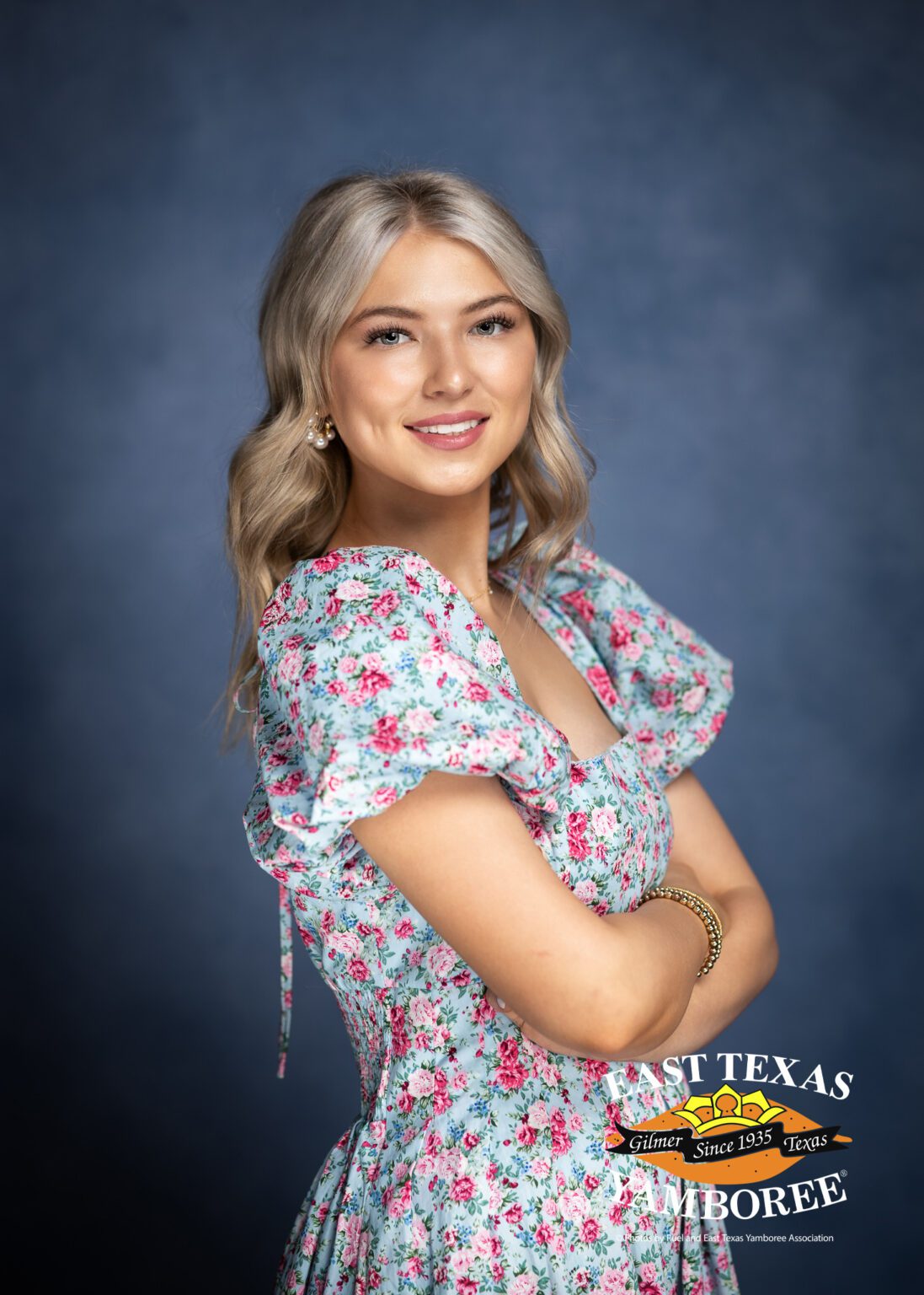 Woman in floral dress, smiling at camera.