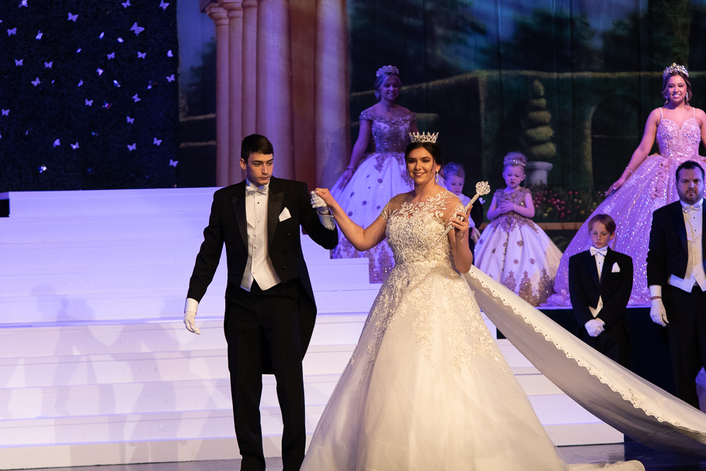 A bride and groom walk down the runway at a wedding.