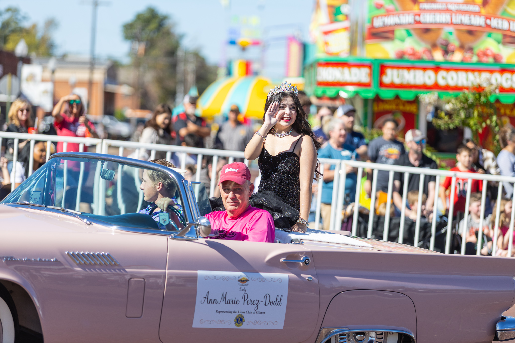 A pink car in a parade.