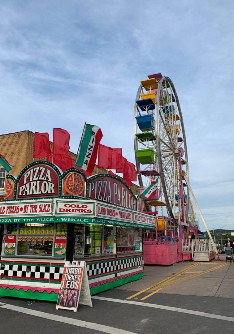 An amusement park with a ferris wheel in the background.